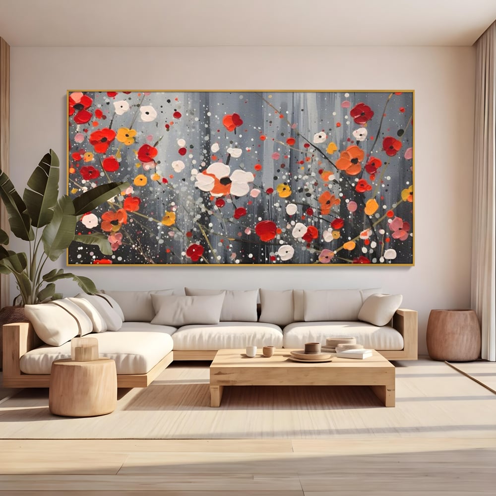 Tablou canvas cu pictura abstracta cu flori si stropi, in rama de aluminiu auriu, pe perete intr-un living